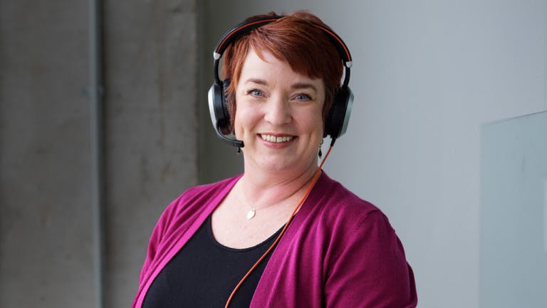 Woman with headphones on smiling to the camera